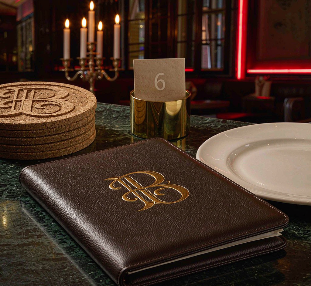 Custom menu covers, coasters and glassware on a table